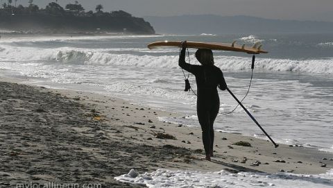 Rhonda Daum taking a walk down the beach after a Cardiff Reef surf session on her stand up paddle board.