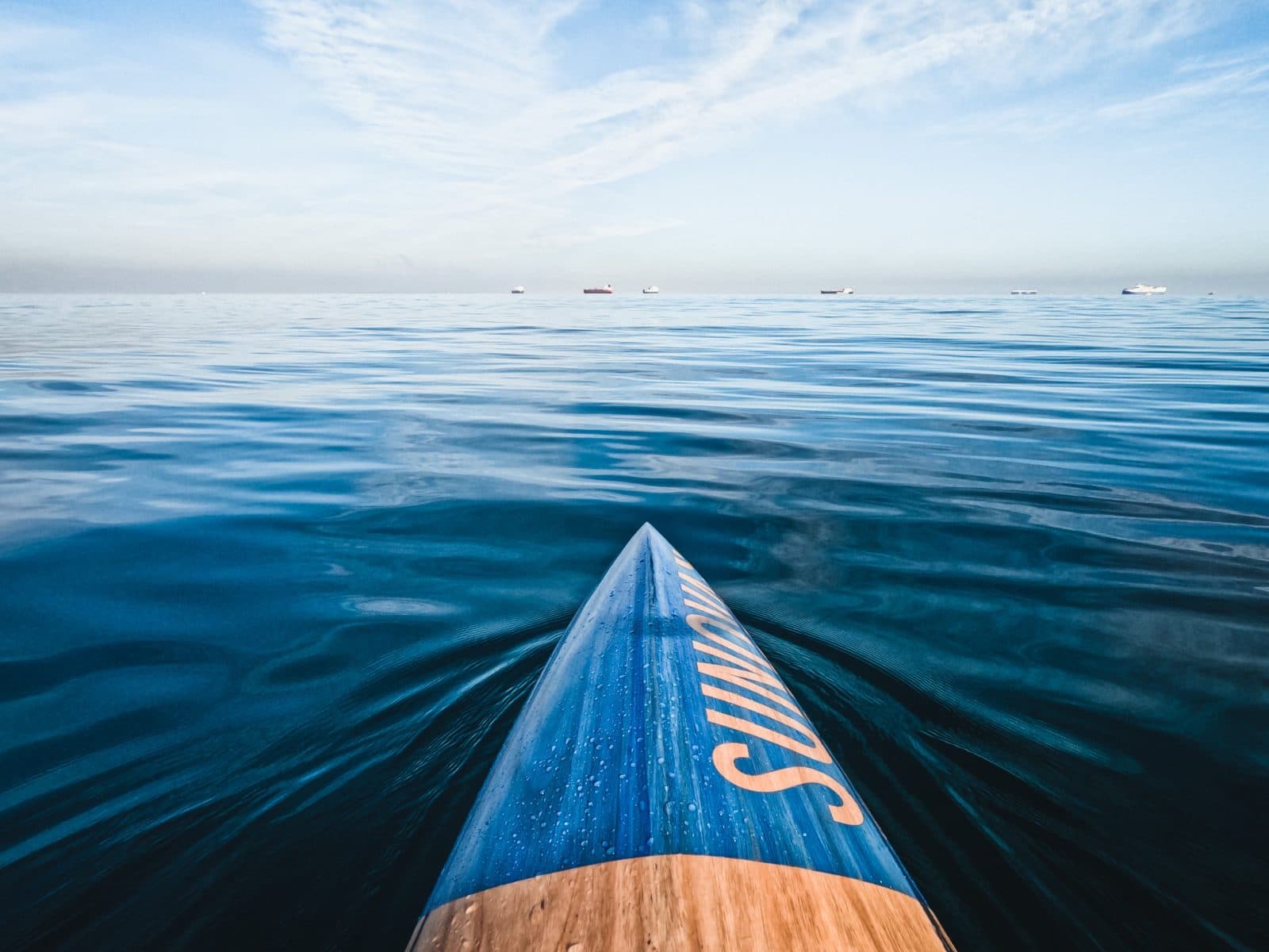 Nose of a paddle board gliding across open water