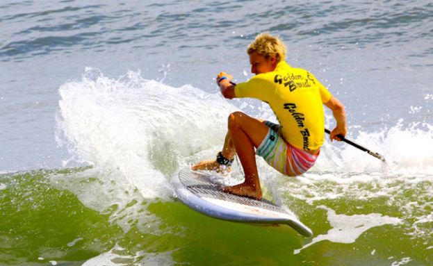 Stand up paddle board surfer working the small righ-hand waves at the Noosa Heads point break.