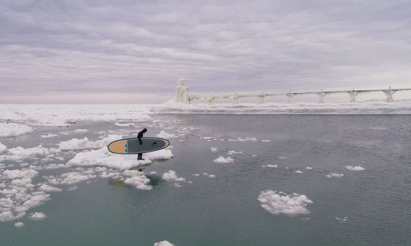 Paddler Karol Garrison braves the cold and readies himself to paddle board the frozen waters of Lake Michigan. | Photo: Seth Haley