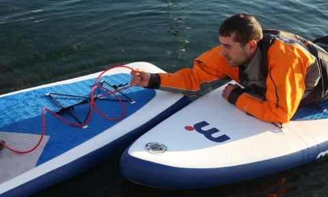 A simple way to set up a tow for a paddler in need is for them to hold onto the leash of the person towing. 