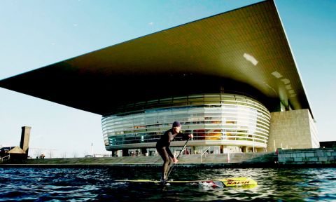 Casper Steinfath paddling in front of the Opera House in Copenhagen, Denmark. | Photo: ISA