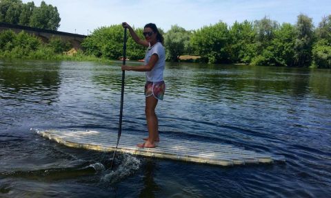 Carolyn paddling her SUP made from plastic bottles. | Photo via: Carlos & Carolyn