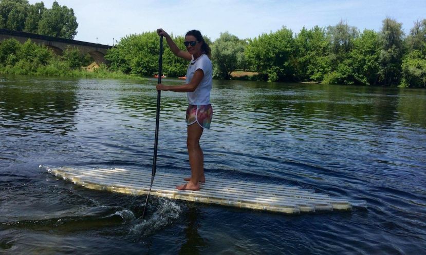 Carolyn paddling her SUP made from plastic bottles. | Photo via: Carlos &amp; Carolyn